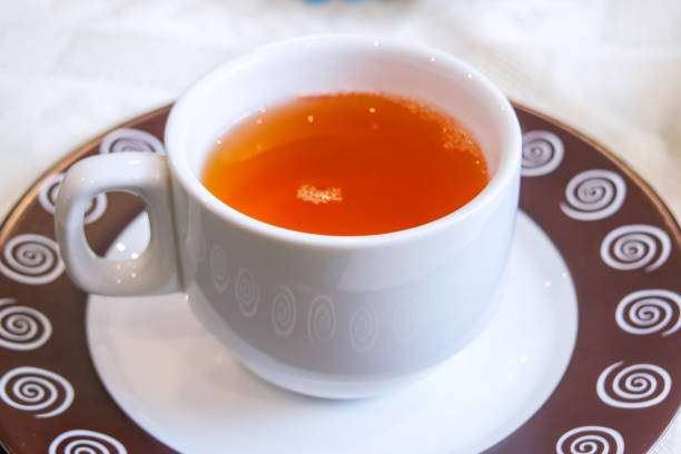 Mug of black tea with an Indian style tea caddy containing tea bags