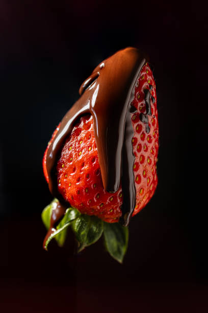 istock Delicious dark chocolate-dipped strawberry on a dark background 2127701315