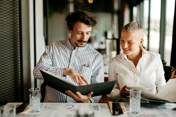Business partners are discussing the menu in a restaurant