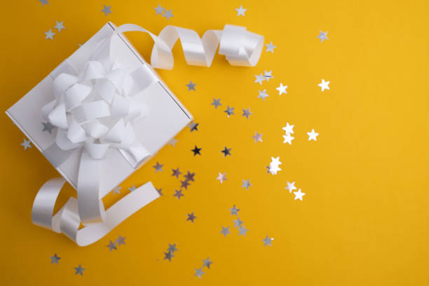 istock Gift or present box and confetti with stars on a colored background. Gift for birthday, mother's day or wedding. Place for text 2127751800