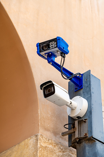 Vicenza, Venetien - Italy - 06-12-2021: Two modern LED surveillance cameras mounted on an old wall monitor the streets of Vicenza