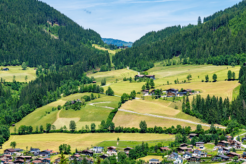 Eben im Pongau, Salzburg - Austria - 06-16-2021: View from hilltop reveals picturesque alpine valley with quaint village, lush trees, and verdant meadows
