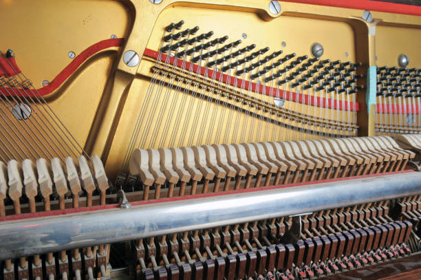 istock Tuner inside of a piano with little hammer 2127790443