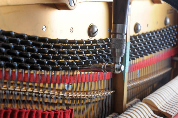 istock Tuner inside of a piano with little hammer 2127790452