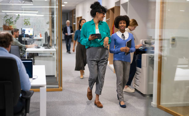 istock Coworkers chatting and walking in office corridor 2127805923