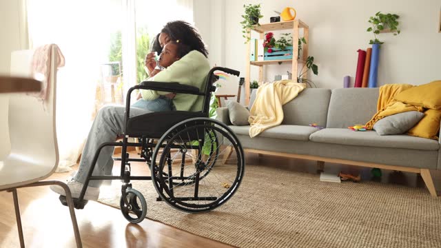 African American woman in a wheelchair taking care of her baby
