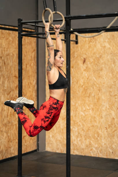 Female athlete training with olympic rings in a gym