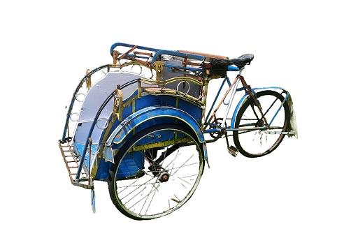traditional three-wheeled transportation or pedicab which is driven by paddles parked isolated on white background.