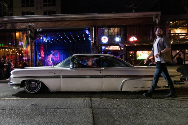 Seattle, USA - Apr 14th, 2023: People checking out a lowrider car club on Pike Street on Capitol Hill late in the evening.
