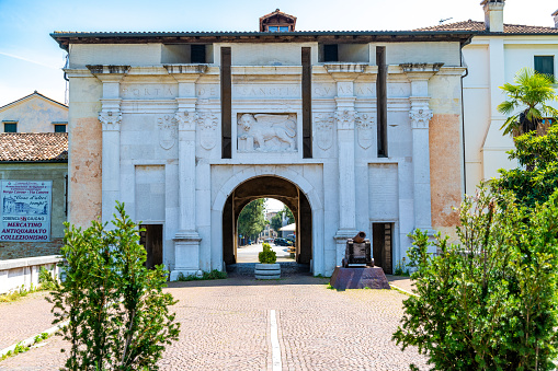 Treviso, Venetien - Italy - 06-13-2021: Porta Santi Quaranta, the white Renaissance gate with a relief of a Venetian lion and intricate columns, marks the rich history and architecture of Treviso