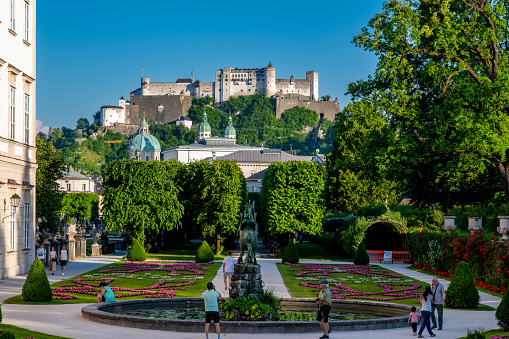 Salzburg, Salzburg - Austria - 06-16-2021: View from the Pegasus Fountain in Mirabell over the towers of Salzburg Cathedral to Hohensalzburg Fortress, a glimpse of the architectural beauty of Austria