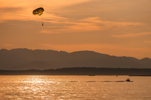 Seattle, USA - Jun 27, 2023: Sunset over Elliott Bay on the waterfront with a Parasail.