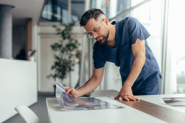 istock Male nurse looking at x-ray image 2128055165