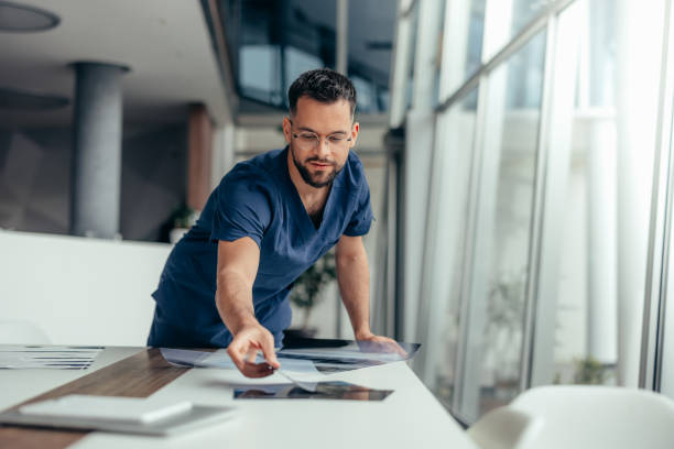 istock Male nurse looking at x-ray image 2128055677