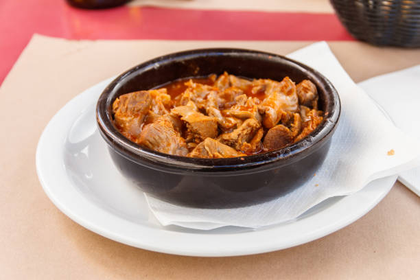 Stewed chicken gizzards in a sauce in a bowl on the table. Typical Spanish appetizer