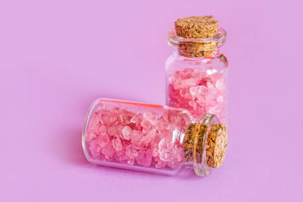 istock Himalayan Pink Salt in glass jars on pink background with copy space for text or design. Himalayan pink salt in crystals. 2128121316