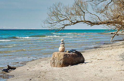 Inukchuk on the beach with scenic view of Lake Ontario in Presqu'ile Provincial Park in early spring