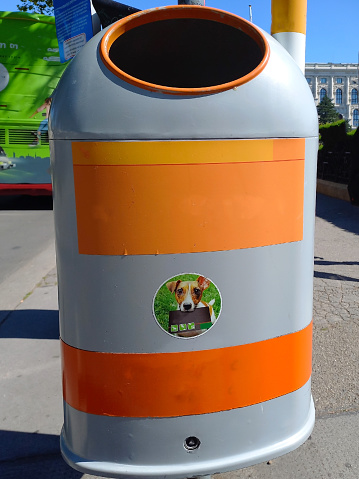 Dog animal waste container with stickers close-up on a city street