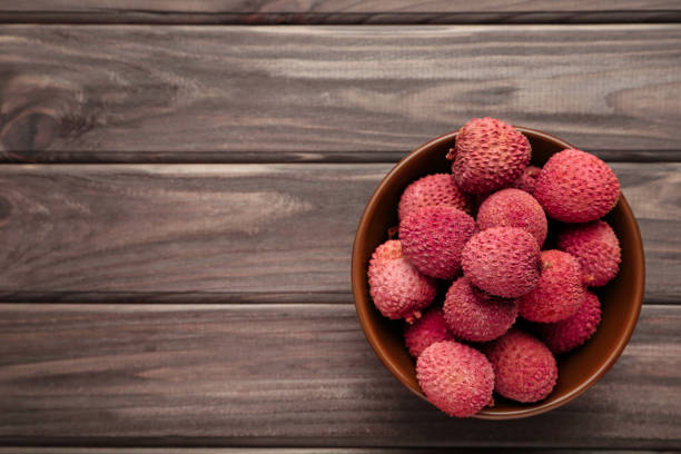 Tasty lychee in bowl on wooden table