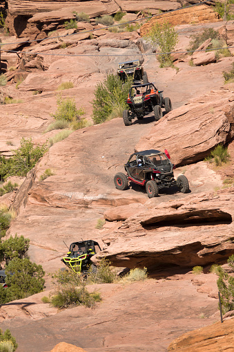 Just outside of the city of Moab, off roaders in buggies climb the steep red rocks along the Moab Rim Trail leaving behind blackened paths of tire rubber.