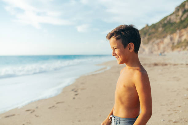 Boy standing at the beach and looking at the view