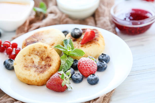istock Sweet cheese pancakes with berries and mint leafs on wooden table 2128135713