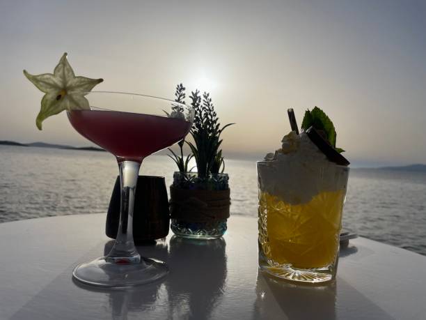 istock Table with two cocktails and water at sunset 2128152748