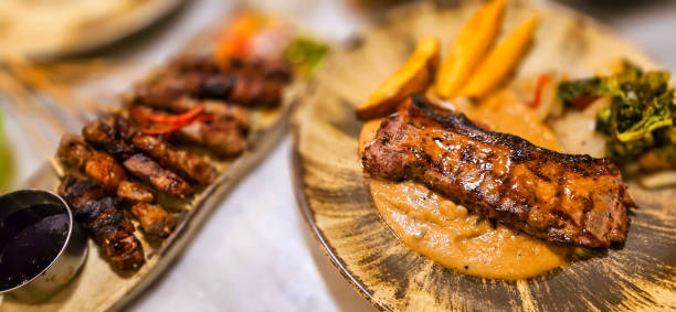 bistecca di lombo di manzo alla new york con salsa di funghi e spicchi di patate e insalata piatta su un bel piatto - steak strip steak prepared potato grilled foto e immagini stock