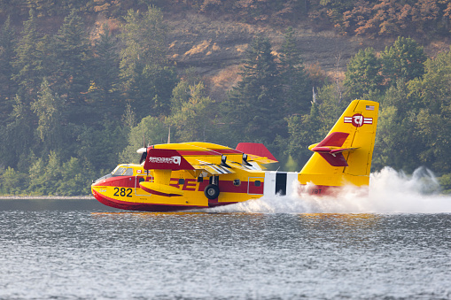 Latourell, Oregon, USA - August 27, 2023: A Bridger Aerospace Canadair CL-215 refills with water from the Columbia River while fighting the Camp Creek fire located in the Bull Run Watershed area of the Mt Hood National Forest.