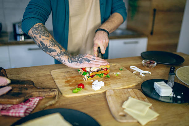 istock Man prepares a club sandwich in the kitchen 2128194249