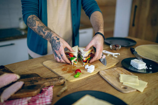 istock Man prepares a club sandwich in the kitchen 2128196360