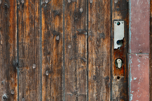 a wooden door with a rusty lock