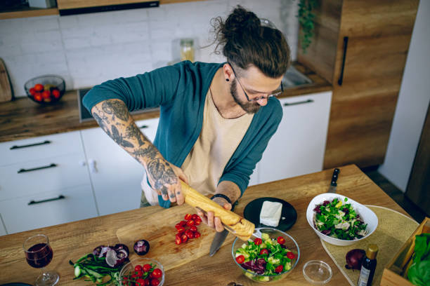 istock Man is preparing a salad in the kitchen 2128204118