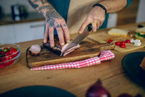 istock Man cutting smoked meat in the kitchen 2128204132
