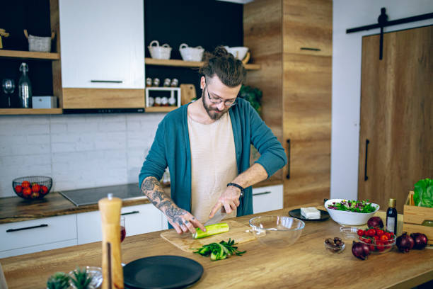 istock Man is preparing a salad in the kitchen 2128214160