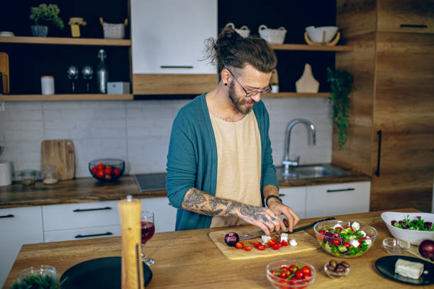 istock Man is preparing a salad in the kitchen 2128215703