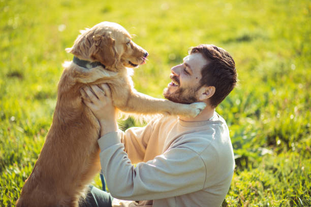 istock Guy and his dog, golden retriever, nature 2128216228