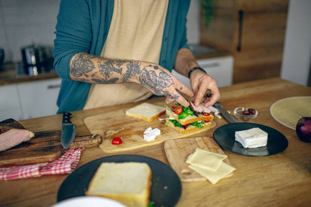 istock Man prepares a club sandwich in the kitchen 2128217267