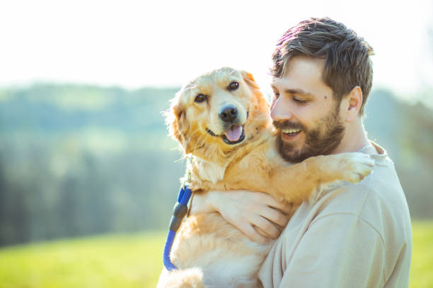 istock Guy and his dog, golden retriever, nature 2128217811