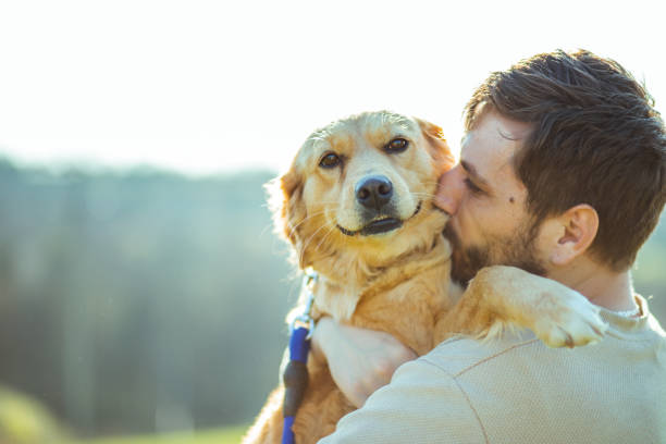 istock Guy and his dog, golden retriever, nature 2128218312