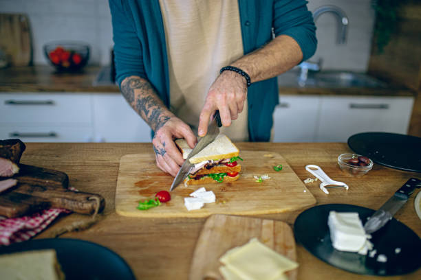 istock Man prepares a club sandwich in the kitchen 2128220888