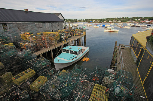 Bass Harbor, Maine - 07-30-2008: Lobster boat at dock surrounded by traps and floats on sunny summer afternoon.