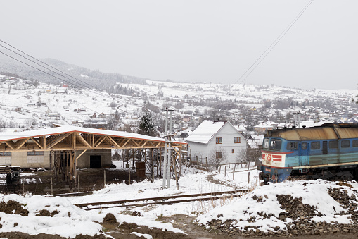 Yasinya, Ukraine. March 19, 2024. It snowed heavily in the morning. Having climbed the mountain, an incredible view of the village, covered with snow, opened up. A train passes by.