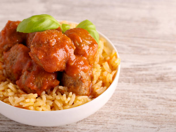 Mini beef meatballs in tomato sauce over rice
