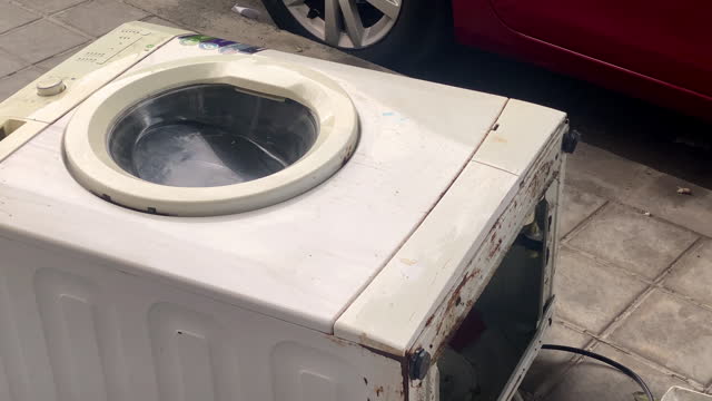 Broken washing machine left in the street