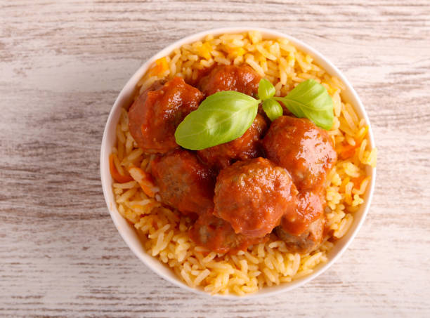 Mini beef meatballs in tomato sauce over rice