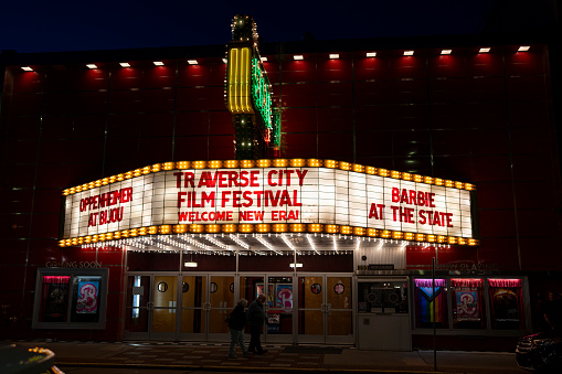 Chicago, Illinois, USA - May 10, 2018: Pedestrians and visitors pass below the Chicago Theatre on State Street at twilight. The historic theater dates from 1921.