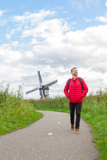 happiness young latin male tourist taking a euro trip around windmills in kinderdijk, south holland, netherlands. - c18 zdjęcia i obrazy z banku zdjęć