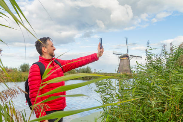 szczęście młody latynoski turysta płci męskiej wybierający się na wycieczkę po wiatrakach w kinderdijk, holandia południowa, holandia. - c18 zdjęcia i obrazy z banku zdjęć