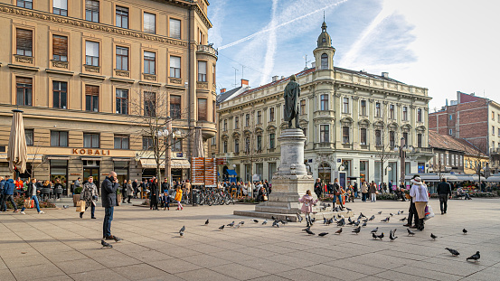 February 3rd, 2024. Zagreb, Croatia. A sunny winter day in the center of the city with doves and a group of random people.